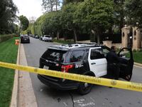 Police cars are seen behind caution tape outside the home of US producer and musician Sean "Diddy" Combs in Los Angeles
