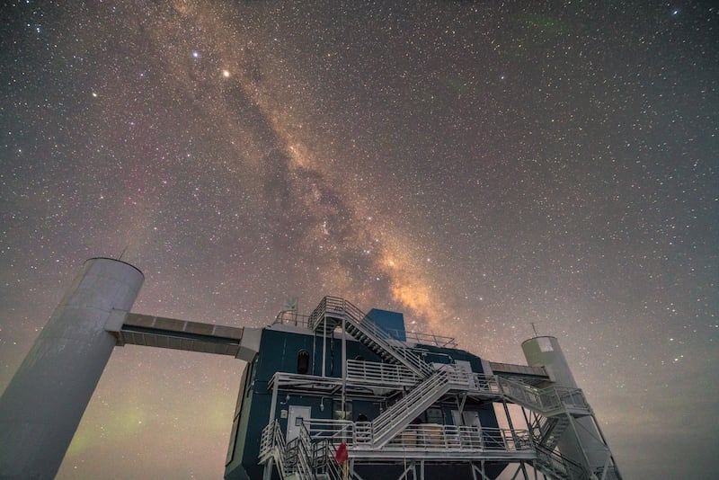 The above-ground portion of the IceCube Neutrino Observatory along with the first-ever neutrino-based image of the Milky Way.