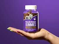Hand holding a package of CBD Gummies for Sleep with Melatonin by CBDfx