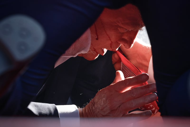 Republican presidential candidate former President Donald Trump is shown covered by U.S. Secret Service agents after an incident during a rally on July 13, 2024 in Butler, Pennsylvania