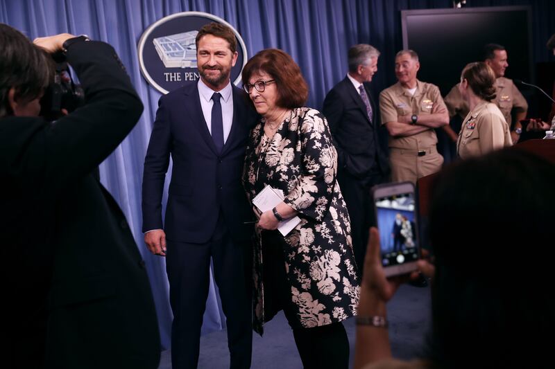 Actor Gerard Butler (left) poses for a photograph with CNN Pentagon correspondent Barbara Starr following a news briefing about his new submarine action film 'Hunter Killer' at the Pentagon October 15, 2018 in Arlington, Virginia.
