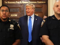 Former US President Donald Trump speaks while the court takes a lunch recess during the first day of his civil fraud trial at New York State Supreme Court