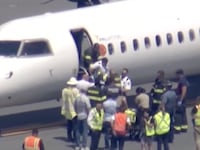 Passengers and pilot disembarking from the plane.