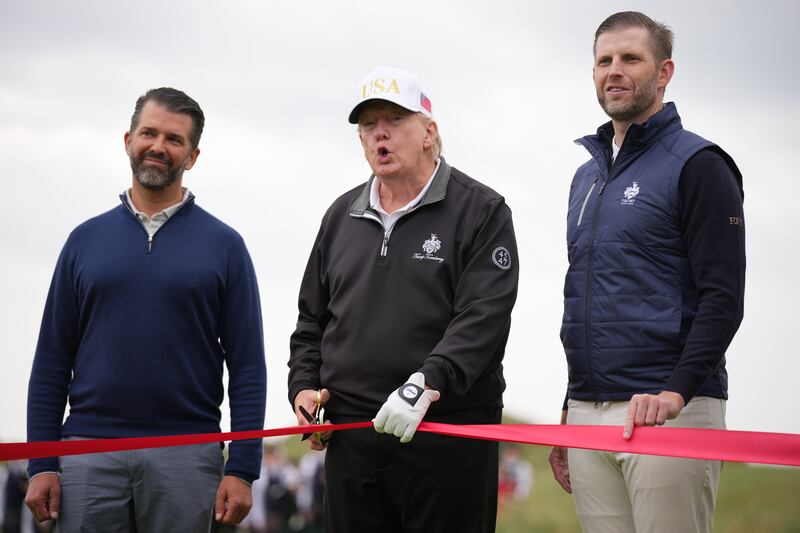 U.S. President Donald Trump speaks next to Donald Trump Jr. (L) and Eric Trump as they attend the ribbon-cutting ceremony at a new 18-hole course at Trump International Golf Links on July 29, 2025 in Balmedie, near Aberdeen, Scotland. President Trump is visiting Scotland in a trip that’s part-vacation, part-work, as he stayed at his Trump Turnberry golf course, followed by Trump International Golf Links in Aberdeenshire, between July 25 to 29.