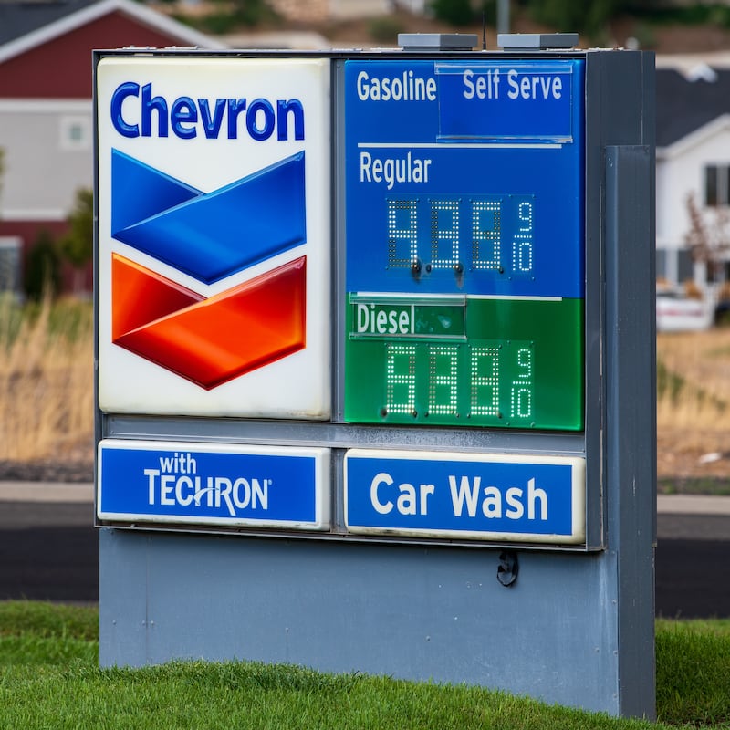 A close-up view shows a Chevron roadside fuel price sign standing near a roadway in Santaquin, Utah, United States, on August 30, 2026. The sign displays current retail pricing for self-serve regular gasoline at $4.35 and diesel at $5.39 per gallon against a background of residential housing.
