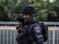 An Israeli police officer stands guard as a search for suspects is underway. Fighting between Israeli soldiers and Islamist Hamas militants continues in the border area with Gaza.