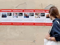 A woman looks at posters depicting missing Israeli citizens likely among the hostages held in Gaza.