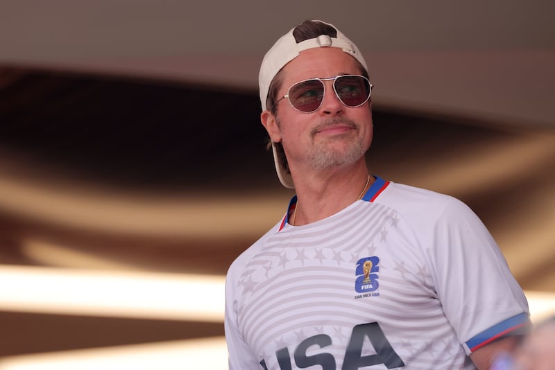 Brad Pitt looks on during the FIFA World Cup 2026 quarterfinal match between Spain and Belgium, wearing a backward hat and his aviator sunglasses.
