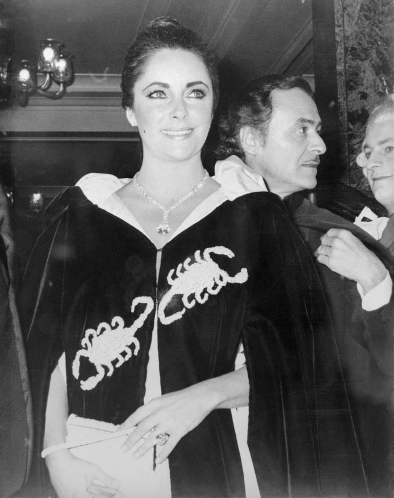(Original Caption) Actress Elizabeth Taylor arrives resplendent for Princess Grace's 40th birthday party November 15th wearing the $1,050,000 diamond her husband actor Richard Burton bought for her. The 69.4 carat gem was displayed on a double strand necklace of smaller diamonds. She set it off by letting it fall deep into the plunging neckline of her gown.