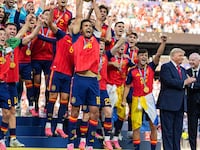 EAST RUTHERFORD, NEW JERSEY - JULY 19: US President Donald Trump and FIFA President Gianni Infantino stand on stage as Rodri #9 of Spain raises the FIFA World Cup Winner’s Trophy with his teammates after they defeated Argentina in the FIFA World Cup 2026 Final at New York New Jersey Stadium on July 19, 2026 in East Rutherford, New Jersey. Spain defeated reigning World Cup champions Argentina, who were led by Lionel Messi, with the lone goal coming from Ferran Torres #7 in the 106th minute of extra time. (Photo by Andrew Harnik/Getty Images)