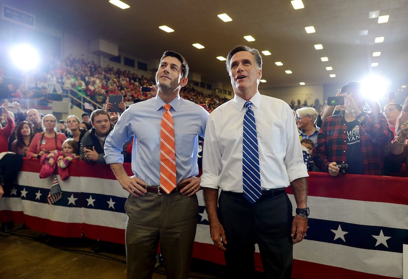US Republican Presidential candidate Mitt Romney and his running mate Paul Ryan sing along during a musical performance at a rally at the Veterans Memorial Coliseum in Marion, Ohio on October 28, 2012. AFP PHOTO/Emmanuel DUNAND (Photo credit should read EMMANUEL DUNAND/AFP via Getty Images)