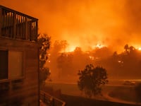 Flames from the Palisades Fire burn homes at Temescal Canyon road during a powerful windstorm on January 8, 2025 in the Pacific Palisades neighborhood of Los Angeles, California. The fast-moving wildfire is threatening homes in the coastal neighborhood amid intense Santa Ana Winds and dry conditions in Southern California.