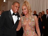 Beyonce smiles next to her husband, U.S. rapper Jay Z, after arriving for the Metropolitan Museum of Art Costume Institute Gala 2015