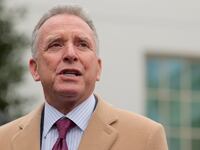 Wearing a striped shirt, blue and red tie, and tan overcoat, Steve Witkoff, special envoy to the Middle East, speaks to the press outside of the White House in March.