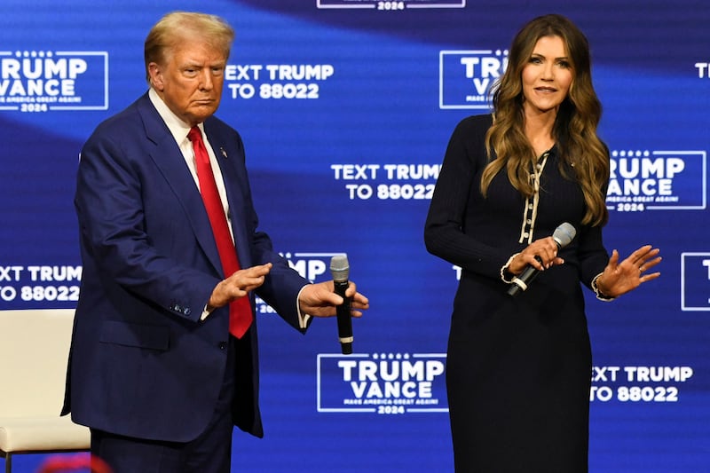 Republican presidential nominee former U.S. President Donald Trump and South Dakota Governor Kristi Noem dance during a town hall campaign event in Oaks, Pennsylvania, U.S., October 14, 2024.
