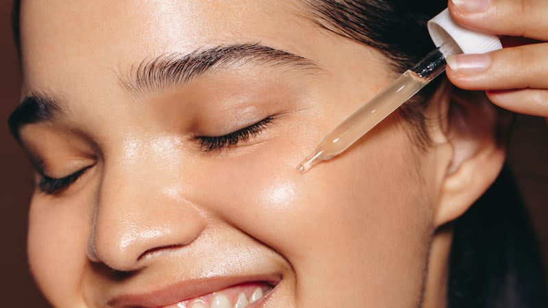 Woman using a skincare serum on her face