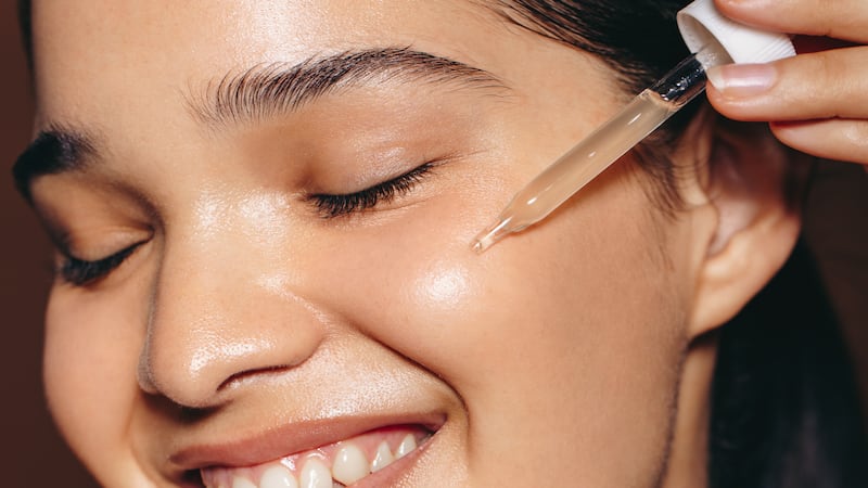 Woman using a skincare serum on her face