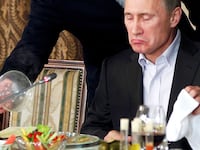 FILE PHOTO: Evgeny Prigozhin (L) assists Russian Prime Minister Vladimir Putin during a dinner with foreign scholars and journalists at the restaurant Cheval Blanc on the premises of an equestrian complex outside Moscow November 11, 2011. Picture taken November 11. REUTERS/Misha Japaridze/Pool/File Photo