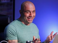 Joe Rogan is shown seated in his podcast studio.