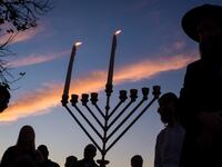 lighting a menorah on the first day of Hanukkah