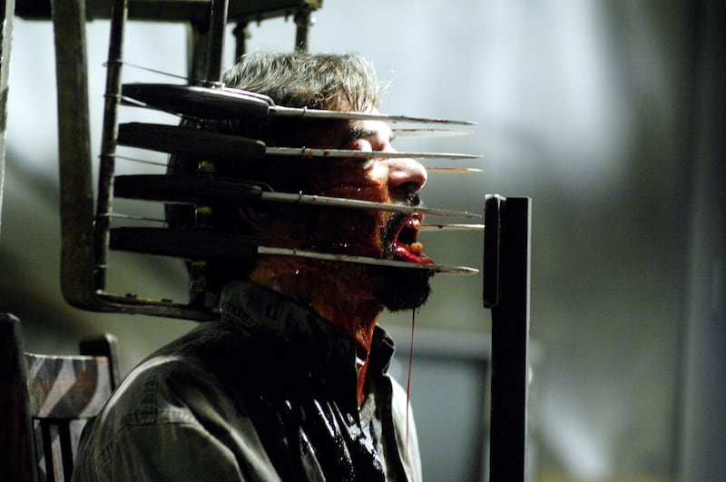 A man sits in a chair made of knives