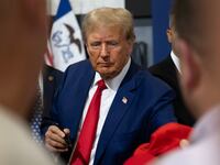 Former President Donald Trump signs items for a crowd of supporters.