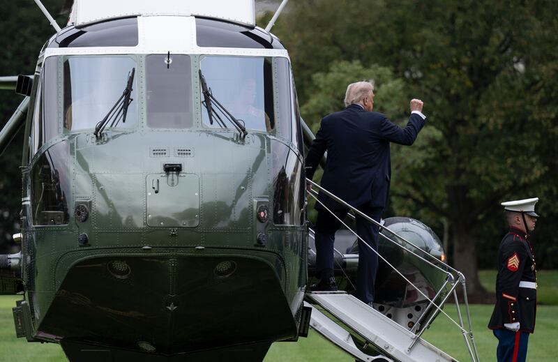 President Donald Trump raises his right fist as he boards Marine One Tuesday.