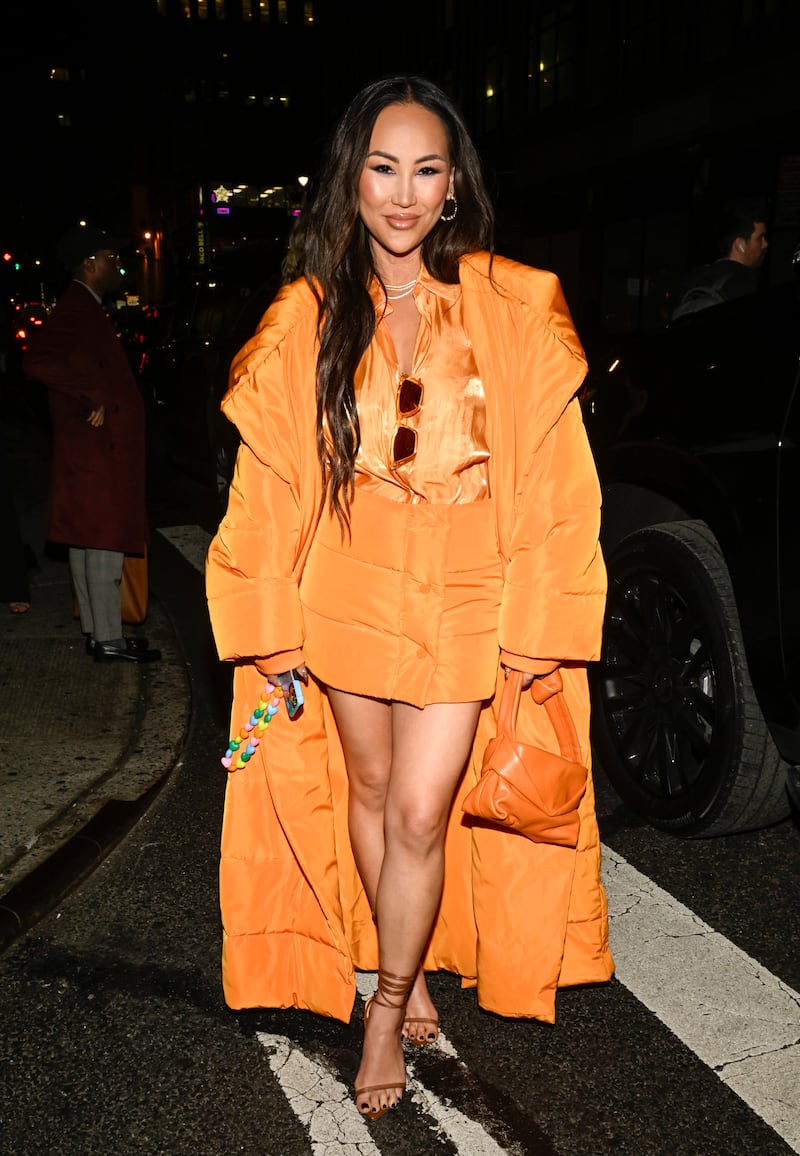 NEW YORK, NEW YORK - FEBRUARY 09: Dorothy Wang is seen wearing a Monse orange puff coat, Monse orange skirt, Bec and Bridge blouse, Staud bag and Tony Bianco heels outside the Christian Siriano show during New York Fashion Week F/W 2023 on February 09, 2023 in New York City. (Photo by Daniel Zuchnik/Getty Images)