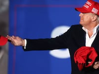 Donald Trump tosses a MAGA hat to the crowd before speaking at a rally at the Canyon Moon Ranch festival grounds on January 15, 2022 in Florence, Arizona.