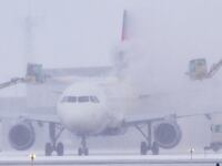 A Delta Air Lines jet is de-iced at Minneapolis-St. Paul International Airport.