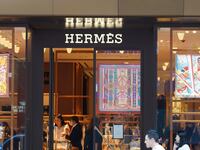 Pedestrians walk past the French luxury design house Hermès logo and store at Harbour City in Hong Kong.