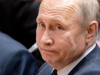 Acting Russian Foreign Minister Sergei Lavrov sits next to Russian President Vladimir Putin at the start of a Peace summit on Libya at the Chancellery in Berlin.