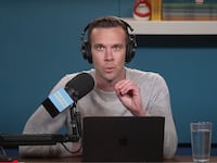 Pod Save America host Jon Favreau speaks into a microphone.