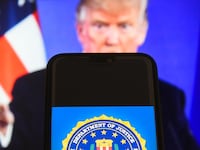 The Federal Bureau of Investigation (FBI) logo is seen with the President of the United States of America, Donald Trump in the background.