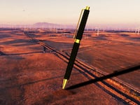 A photo illustration of a giant pen stuck into the ground in Solano County, California.