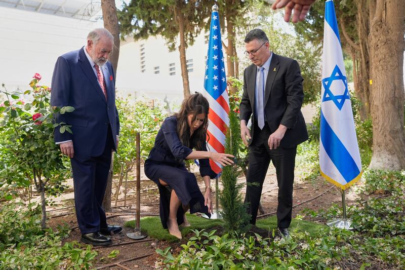 Kristi Noem plants a tree with Israel's Foreign Minister Gideon Sa'ar as U.S. Ambassador to Israel Mike Huckabee looks on in Jerusalem.