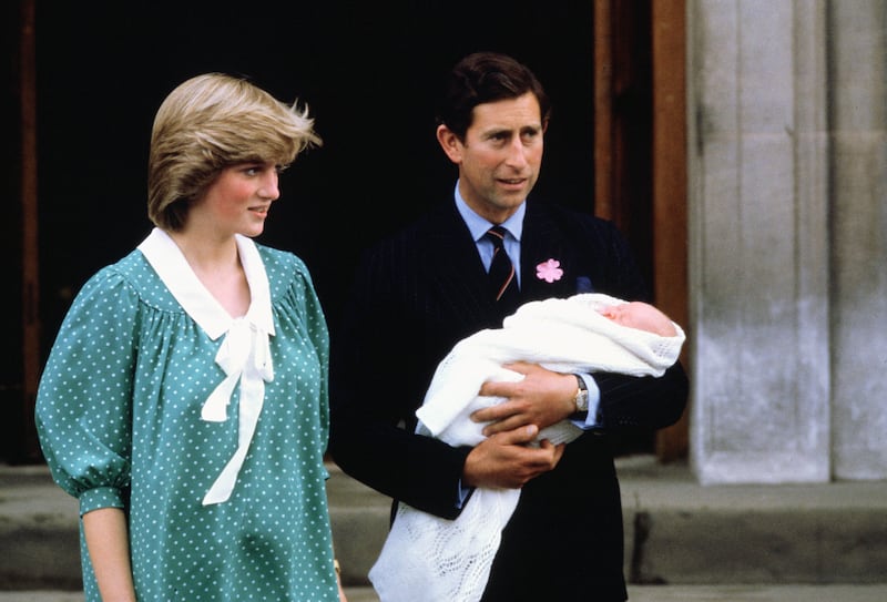 A photo of Princess Diana and Prince Charles holding baby Prince William.