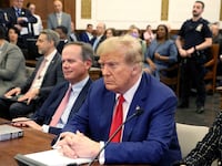 Donald Trump sitting between lawyers in the New York courthouse where his civil fraud trial was held.