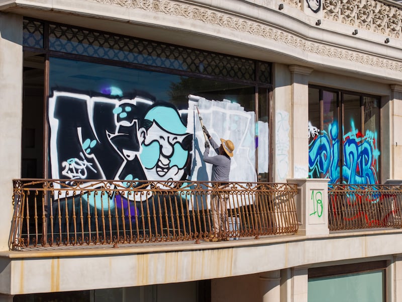 A worker pastes over graffiti on the Mulholland Drive mansion.