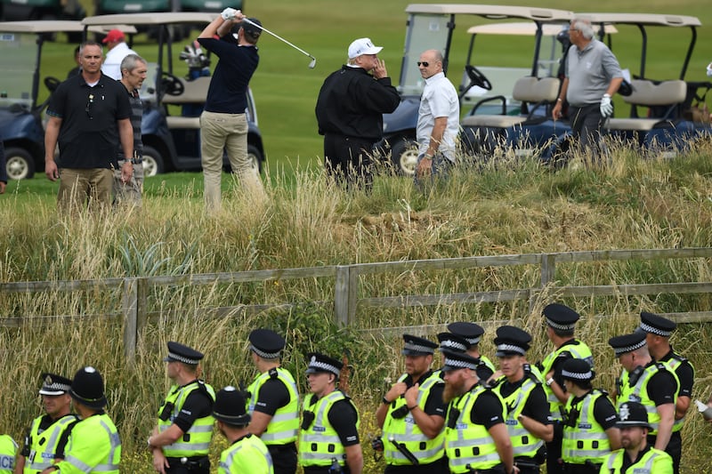 Police secure the area as U.S. President Donald Trump, wearing a hat with Trump and USA displayed on it, plays golf at Trump Turnberry Luxury Collection Resort during the President's first official visit to the United Kingdom on July 14, 2018 in Turnberry, Scotland.