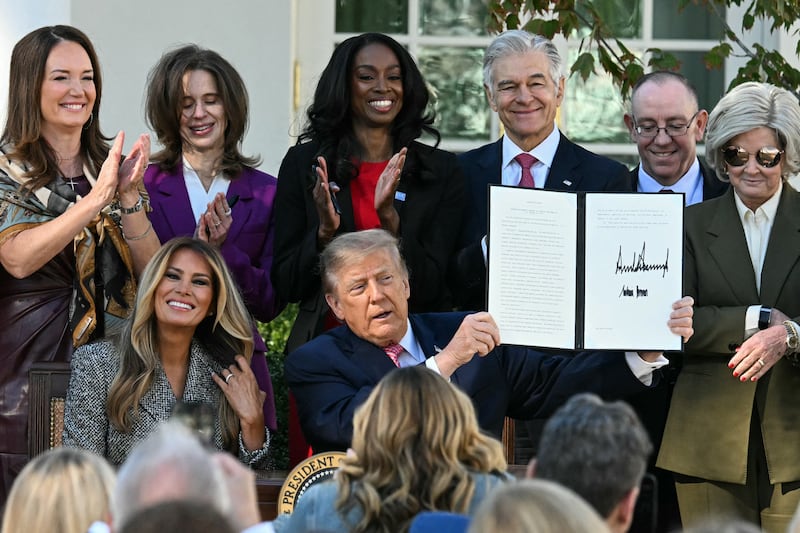 President Donald Trump holds a signed executive order alongside First Lady Melania Trump during a signing ceremony in the Rose Garden of the White House in Washington, DC, on October 19, 2026.