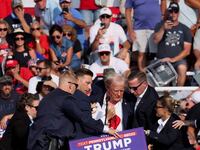 Secret Service surround a bloodied Donald Trump as his supporters behind him look on