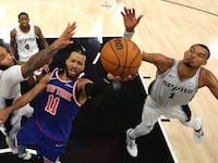 Jalen Brunson of the New York Knicks shoots the ball between Julian Champagnie and Victor Wembanyama