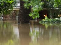 A home in River Plantation is seen with its lights on in flood water.