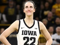 Guard Caitlin Clark #22 of the Iowa Hawkeyes listens as the crowd cheers after breaking the NCAA women's all-time scoring record during the game against the Michigan Wolverines at Carver-Hawkeye Arena on February 15, 2024 in Iowa City, Iowa.