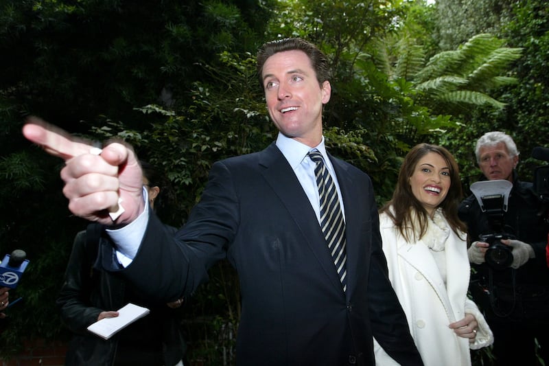 SAN FRANCISCO - DECEMBER 9 : San Francisco mayoral candidate Gavin Newsom (L) and his wife Kimberly Guilfoyle-Newsom leave a polling place after they cast their ballots for the mayoral run-off election December 9, 2003 in San Francisco. Newsom is facing a run-off election against green party candidate Matt Gonzalez. (Photo by Justin Sullivan/Getty Images)