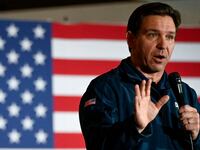 Republican presidential candidate and Florida Governor Ron DeSantis gestures as he speaks at a campaign event at The Thunderdome in Newton, Iowa