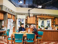 A still from And Just Like That showing Sara Ramirez and Tony Danza on a soundstage for Che Diaz’s comedy pilot.