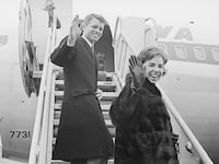 Robert F. Kennedy and his wife, Ethel, wave from ramp of plane as they prepare to depart on a globe-circling, 26-day good-will tour to Japan, Indonesia, Iran, Italy, the Netherlands, and West Berlin in 1962.