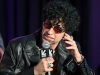 Sebastian Chacon holds a microphone while speaking on stage at an event.